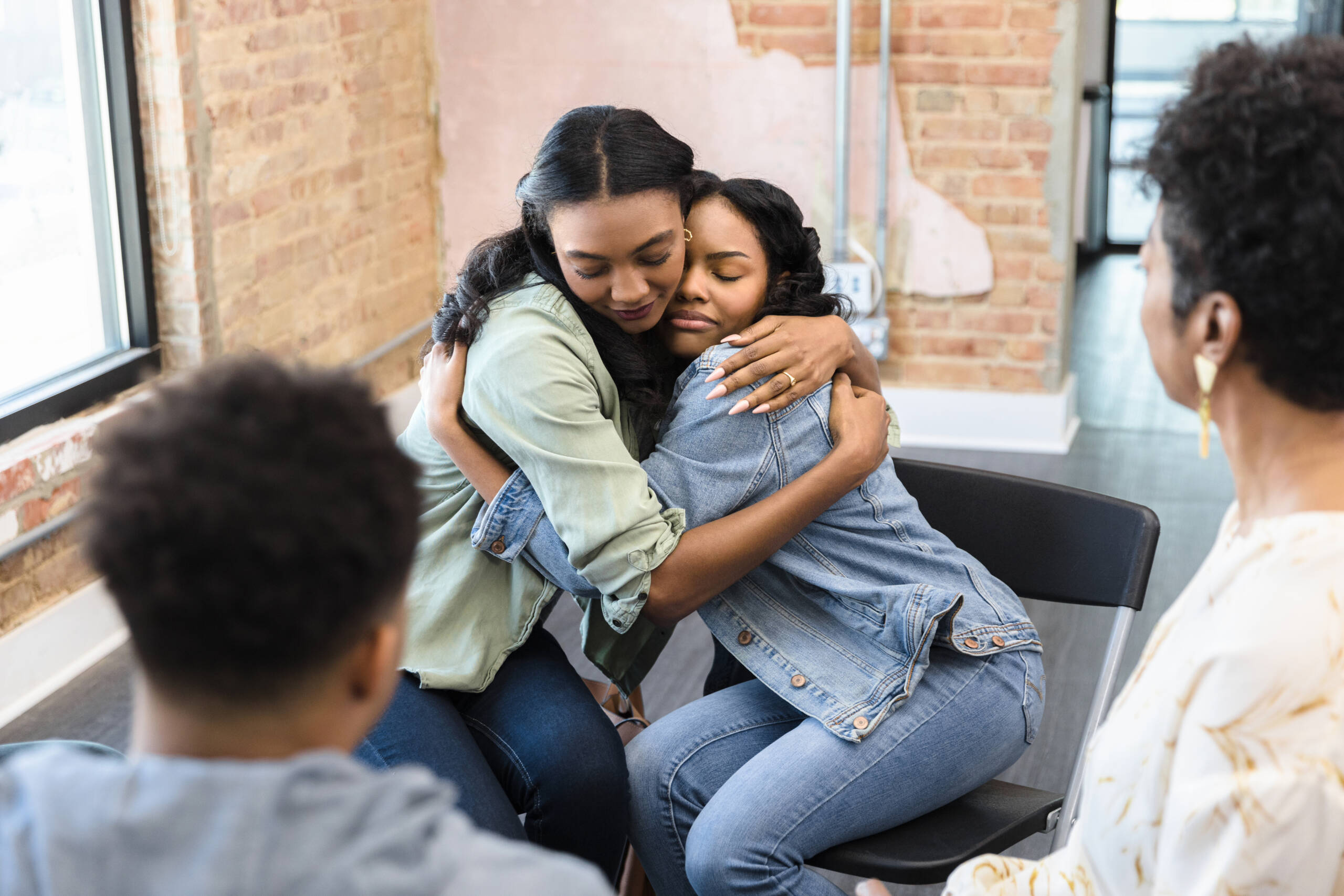 The sisters embrace and make up after working through their issues in group therapy.